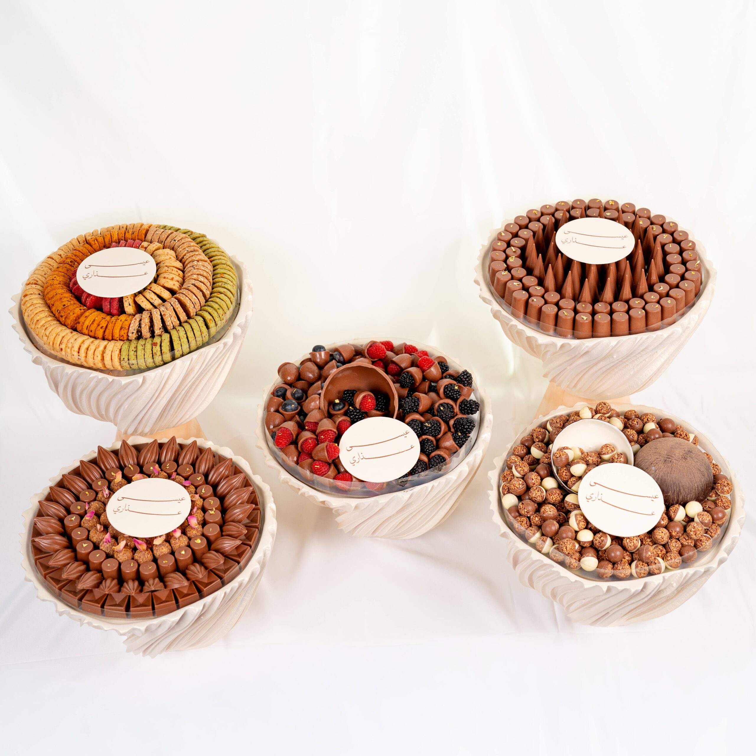 Luxury wedding chocolate collection with assorted chocolates and macarons arranged in elegant round displays