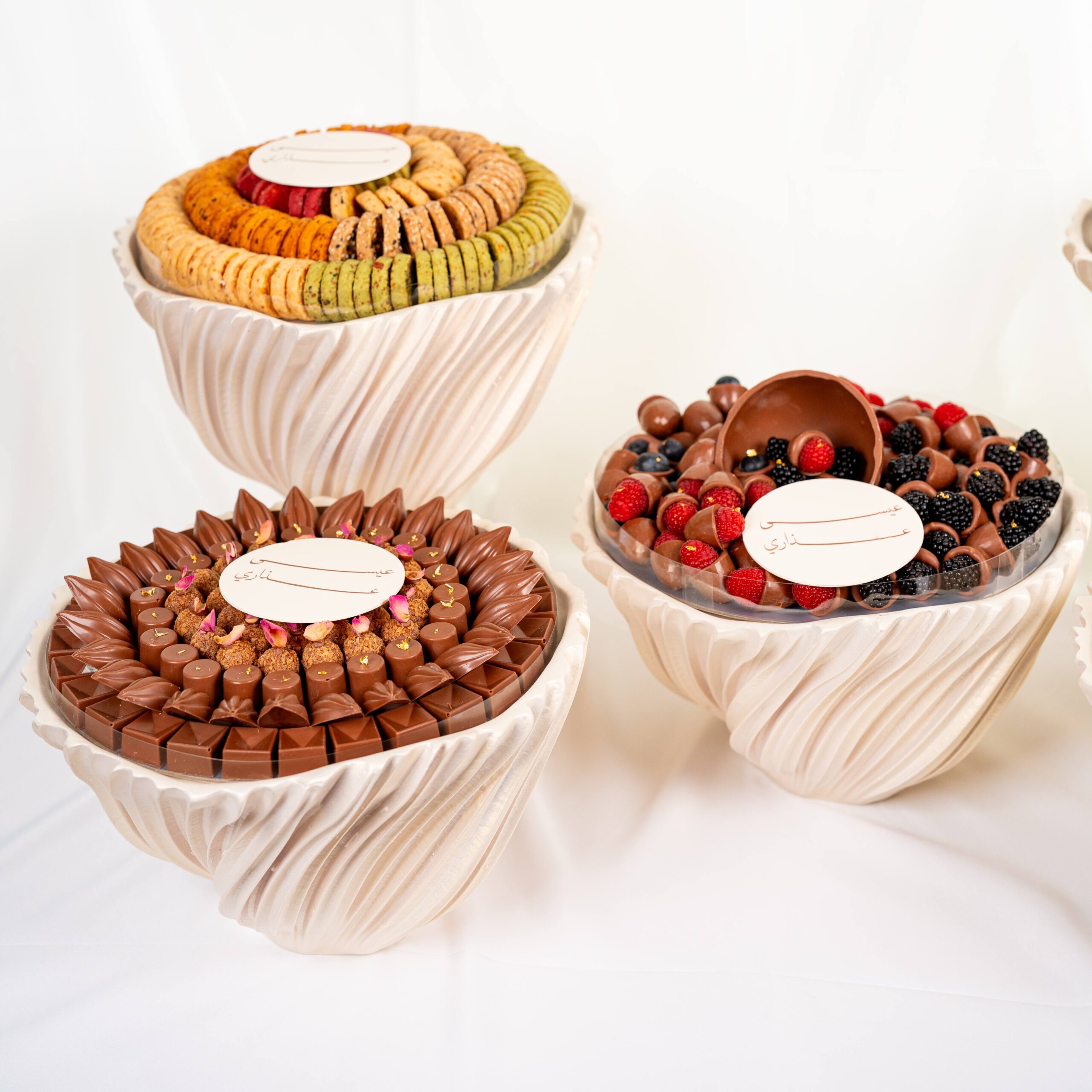 Luxury wedding chocolate collection with assorted chocolates and macarons arranged in elegant round displays