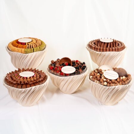 Luxury wedding chocolate collection with assorted chocolates and macarons arranged in elegant round displays