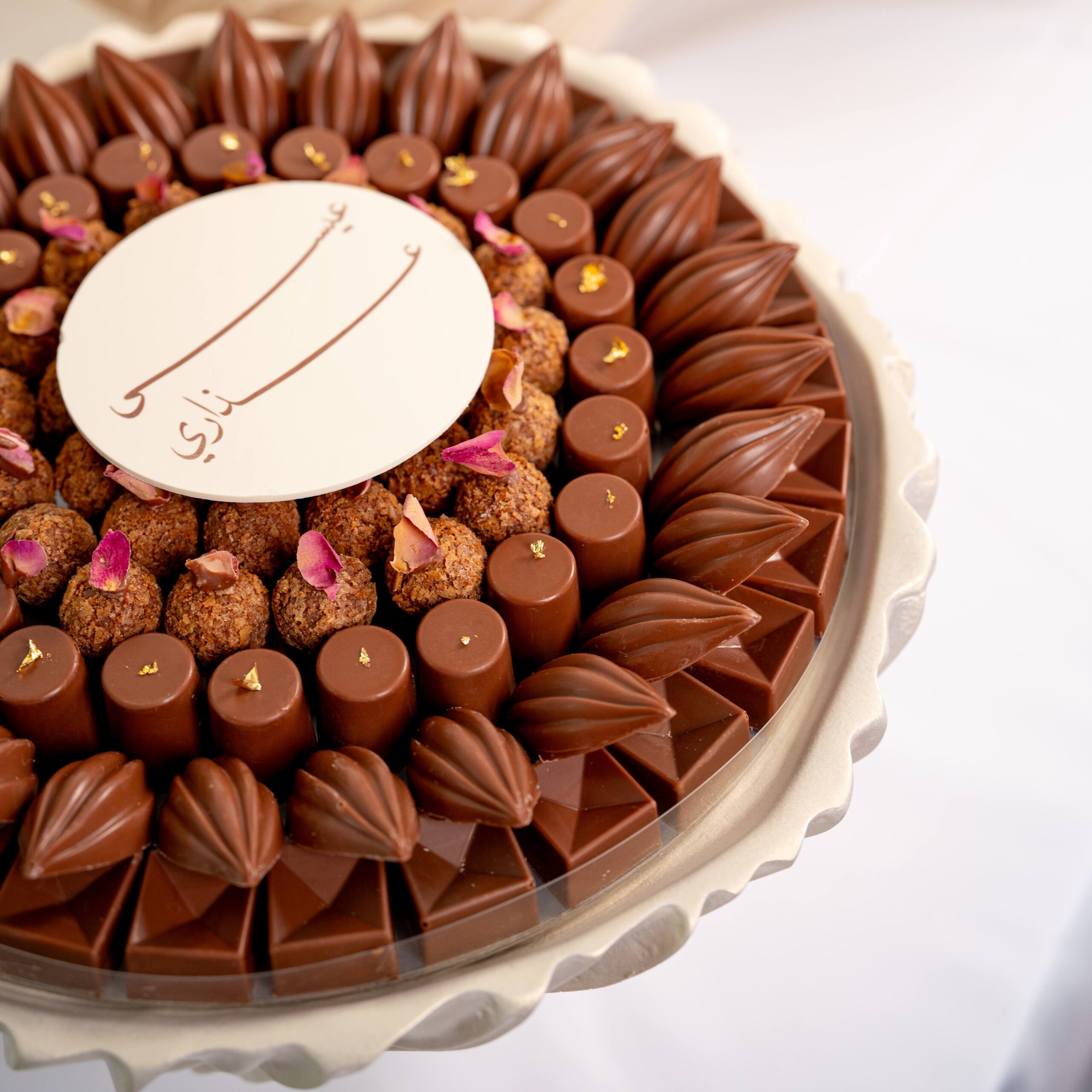 Luxury wedding chocolate collection with assorted chocolates and macarons arranged in elegant round displays