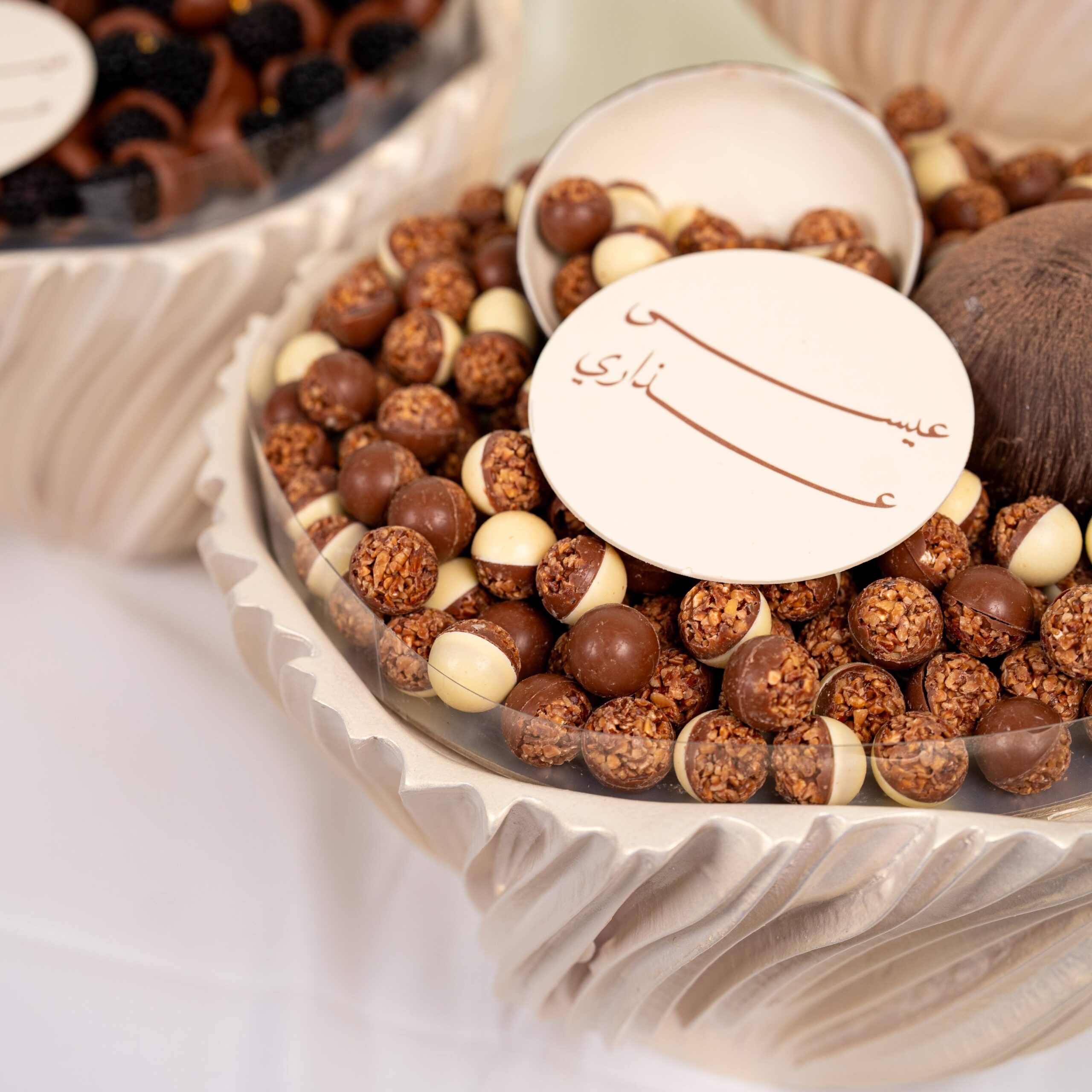 Luxury wedding chocolate collection with assorted chocolates and macarons arranged in elegant round displays