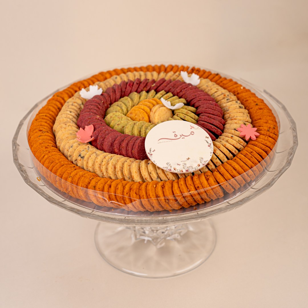 Side view of a pedestal cookie platter decorated with white and pink flowers