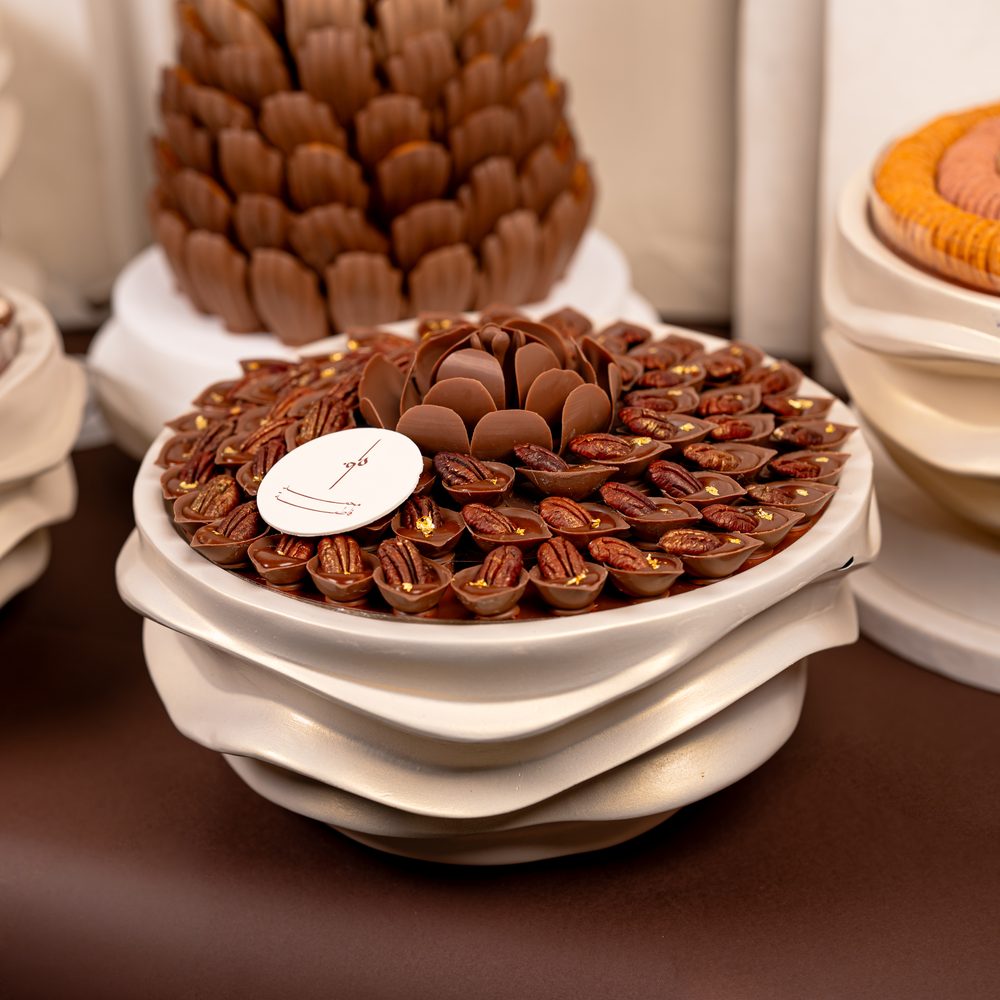 Luxury wedding chocolate set with a tall chocolate cone centrepiece and four cream wave stands holding chocolates and macarons