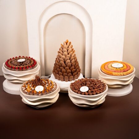 Luxury wedding chocolate set with a tall chocolate cone centrepiece and four cream wave stands holding chocolates and macarons