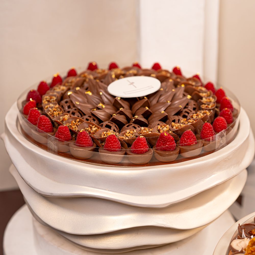 Luxury wedding chocolate set with a tall chocolate cone centrepiece and four cream wave stands holding chocolates and macarons